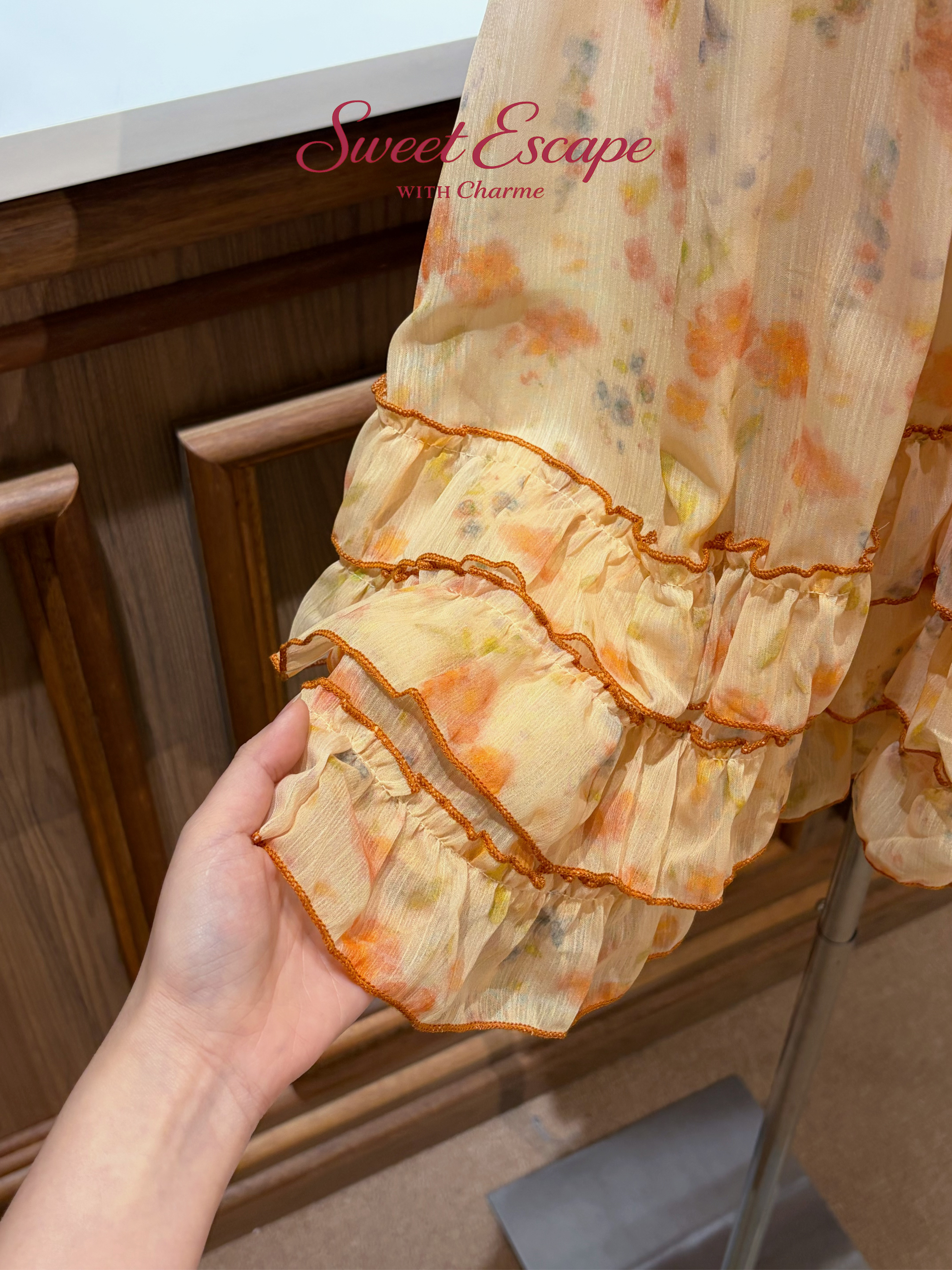 Close-up detail of floral print chiffon dress with layered ruffle hem