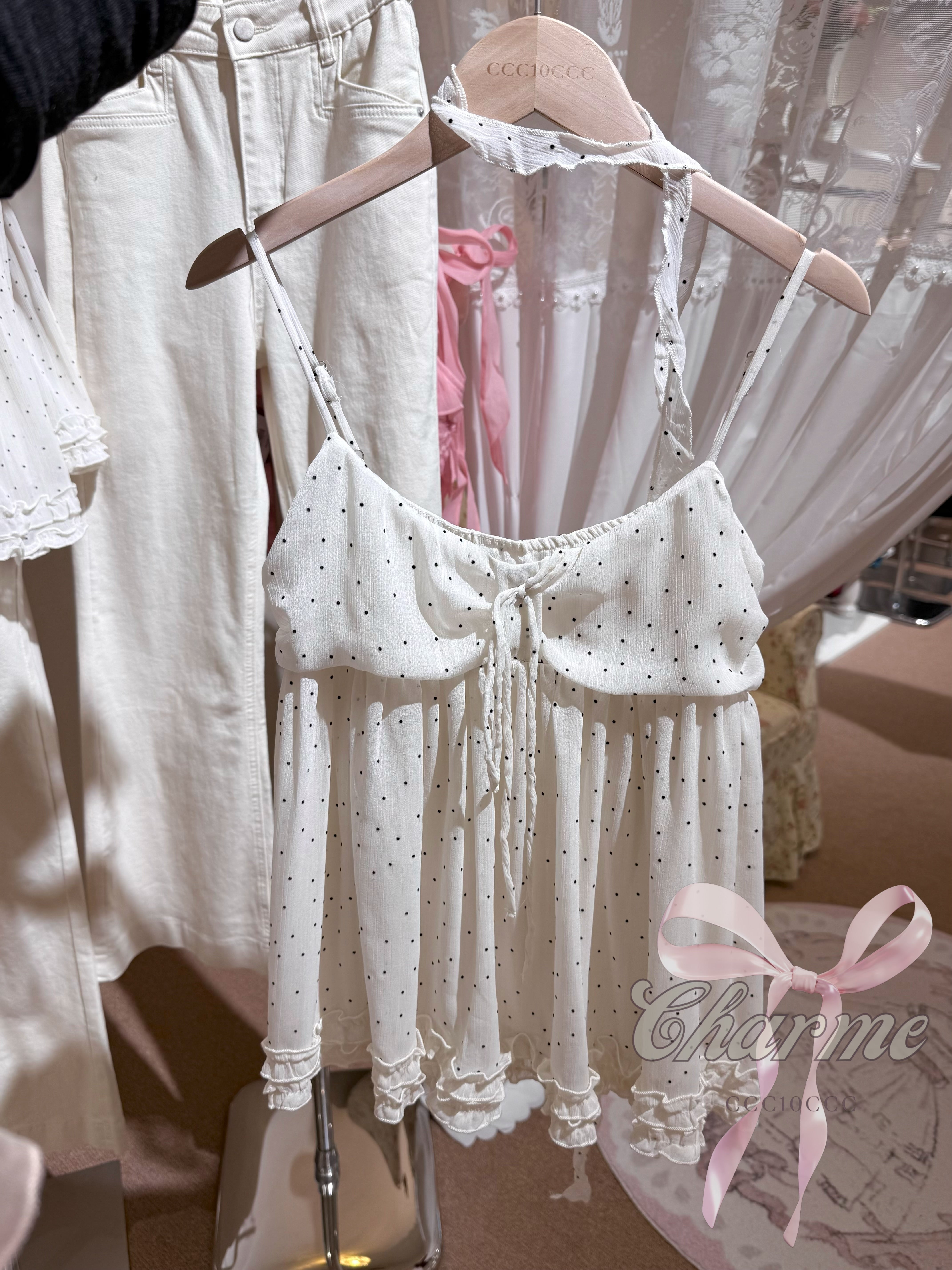 White lace baby outfit on a hanger with 'Charme' branding.