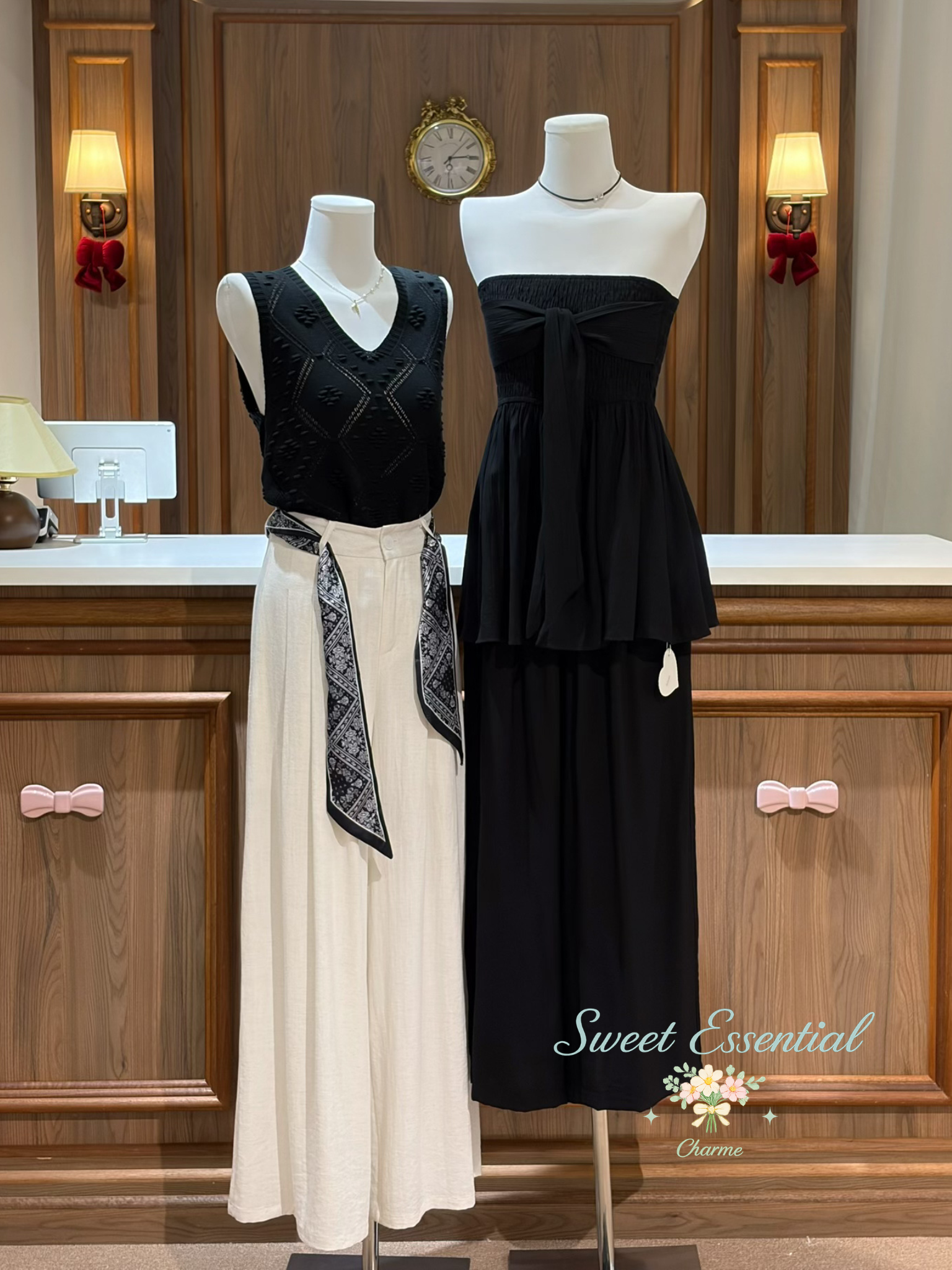 Two mannequins wearing black and white outfits in a room with wooden cabinets and decorative elements.