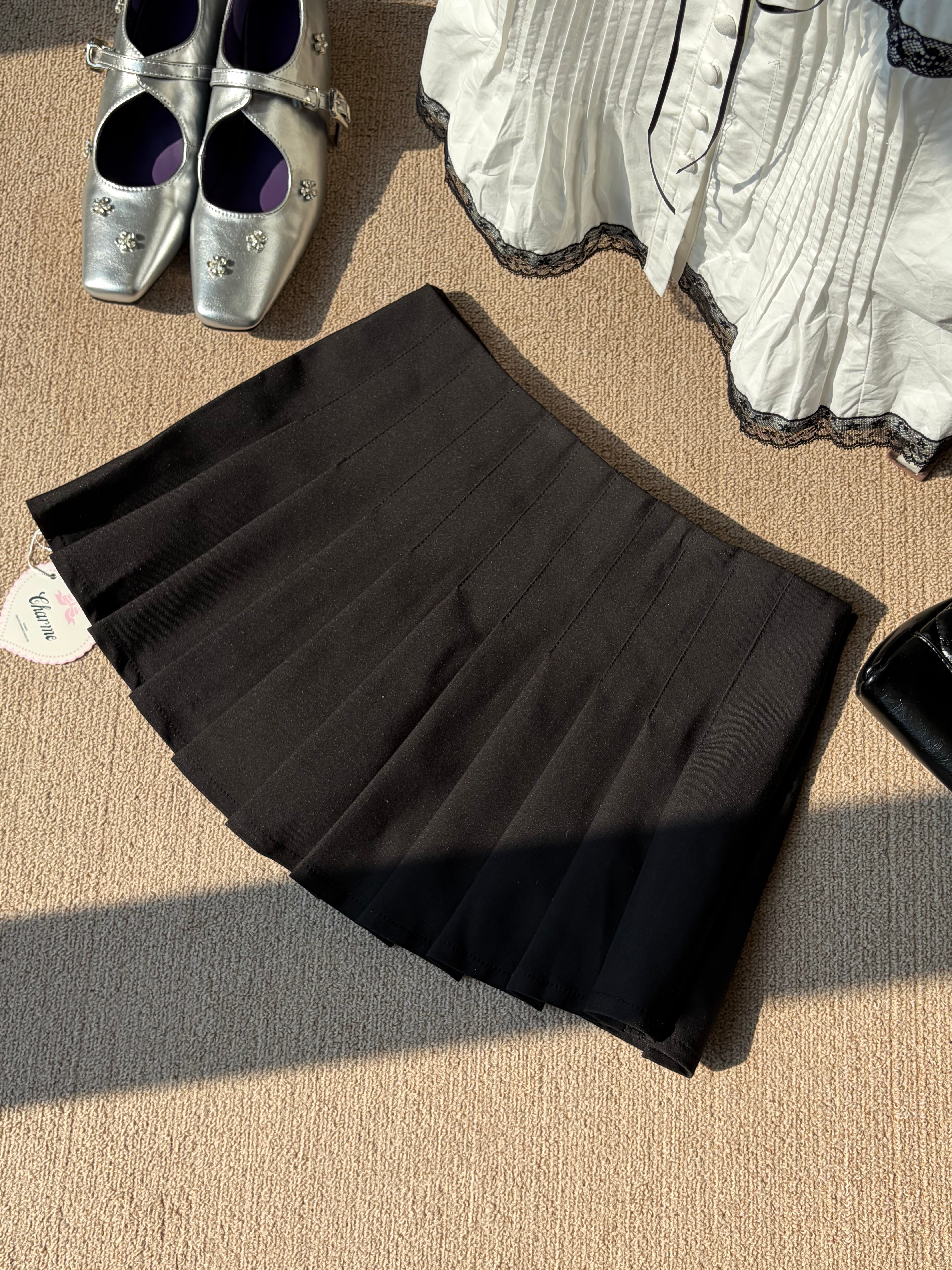 Charme.cc Clara Pleated Skirt - Black Mini Skirt with Asymmetrical Waist and Triple Button Details